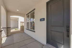 View of exterior entry featuring stucco siding and a patio area