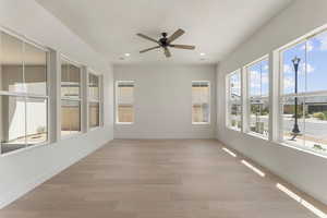 Unfurnished sunroom with wood finished floors and recessed lighting