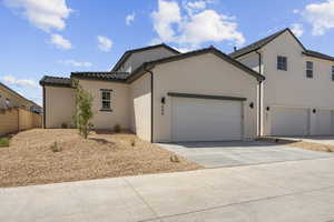 View of front of house featuring stucco siding, concrete driveway, a garage, and a tile roof
