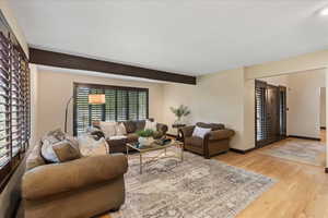 Living room featuring large windows and plantation shutters, exposed beam and views!