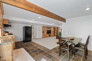 Dining area of Mother Inlaw Apartment with beam ceiling, recessed lighting, and dark stone finish flooring