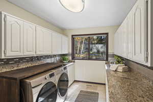 Laundry Room featuring abundant cabinet and counter space, sink and large window.