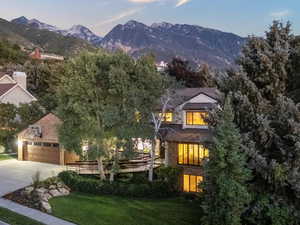 View of front of property with driveway, a garage, a mountain view, a chimney, and a front lawn