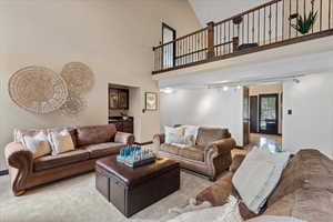 Soaring ceilings and a large space with wet bar and access to the foyer, kitchen and main floor bedroom.