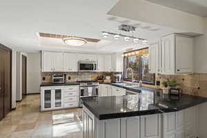 Huge Kitchen with a peninsula, white cabinets, and abundant counterspace. Large window with views to the backyard and deck.