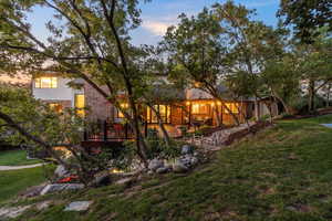 Back of home featuring a Trex deck, pergola and water feature