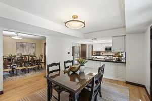 Breakfast area with light wood floors opens to the kitchen and gorgeous deck and backyard