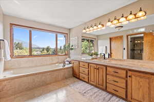 Ensuite Bathroom with vanity, a bath, light tile patterned floors, a stall shower, and a mountain view