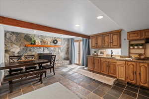 Kitchen of Mother Inlaw Aparment featuring brown cabinets, light stone counters, recessed lighting, beam ceiling, and open shelves