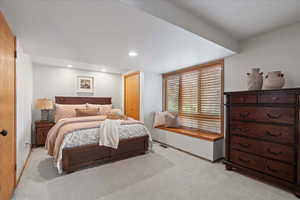 Bedroom in Basement Apartment featuring light colored carpet, a closet, and recessed lighting