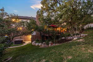 Back of home featuring a Trex deck, pergola, water feature and hot tub