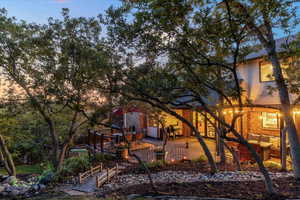 Back of home featuring a Trex deck, pergola and water feature