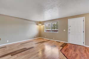 Foyer entrance featuring a textured ceiling and light wood-style floors