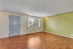 Entryway with light wood finished floors and a textured ceiling