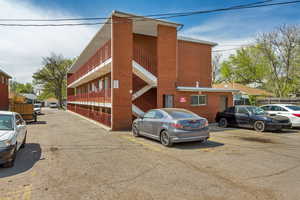 View of building exterior featuring uncovered parking
