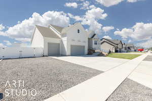 View of front of house featuring a gate, board and batten siding, a residential view, driveway, and an attached garage