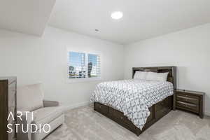 Bedroom with light colored carpet and baseboards