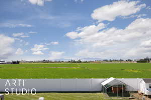 View of yard featuring a view of countryside, a mountain view, an outbuilding, and exterior structure