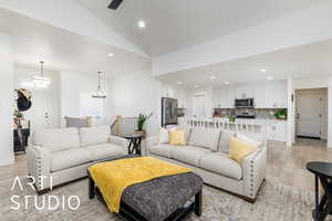 Living area featuring light wood-type flooring, recessed lighting, vaulted ceiling, and a chandelier