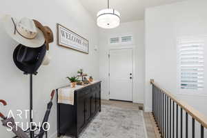 Foyer with light wood finished floors and baseboards