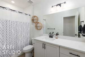 Bathroom with vanity, a shower with curtain, and recessed lighting