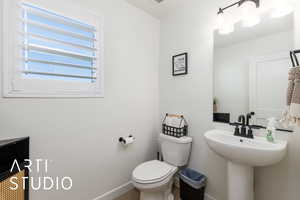Half bath with toilet and baseboards