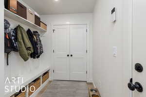 Mudroom with light wood-type flooring and baseboards