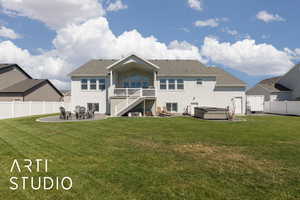 Rear view of property with a hot tub, a patio, stairs, and a fenced backyard