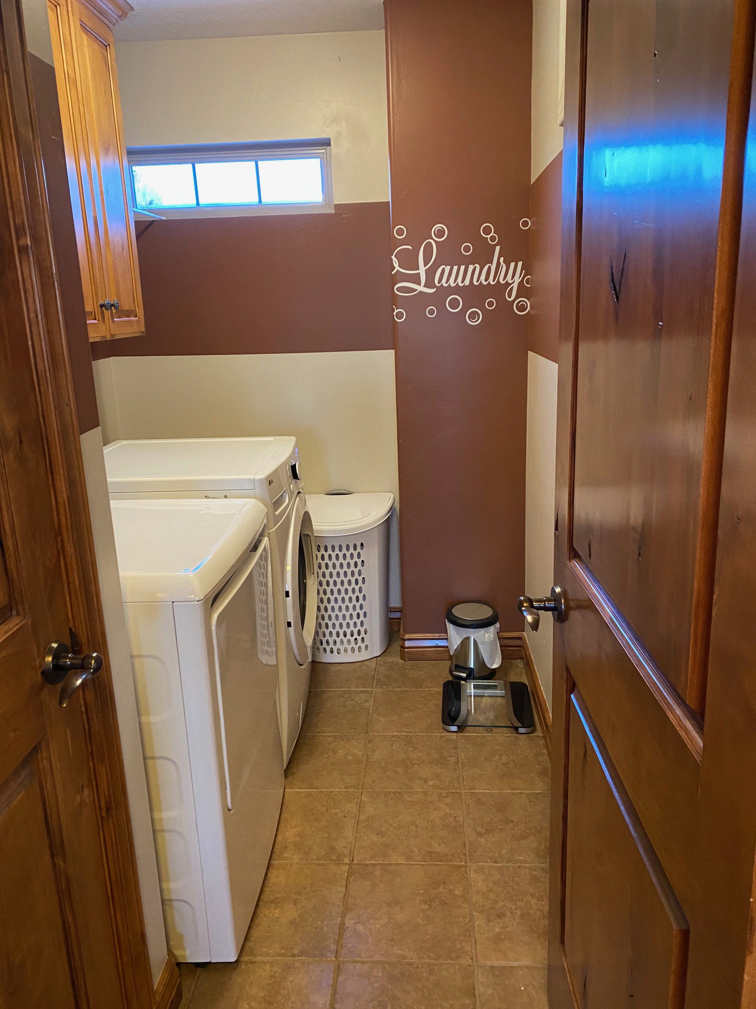 Laundry room with cabinet space, light tile patterned flooring, and washer and dryer