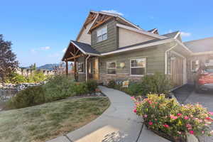Craftsman-style home featuring stone siding and a front lawn