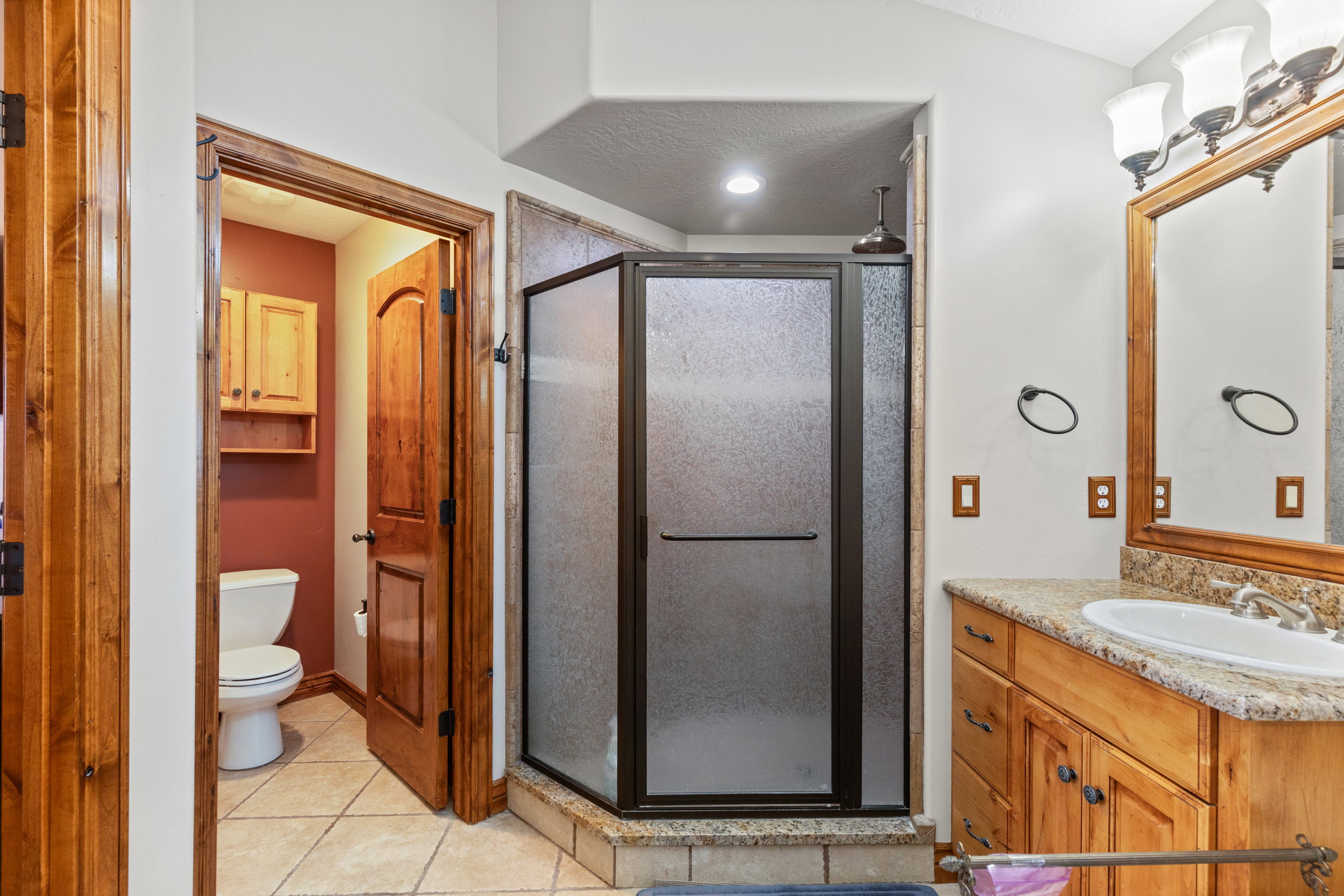 Bathroom featuring tile patterned flooring, vanity, and a shower stall