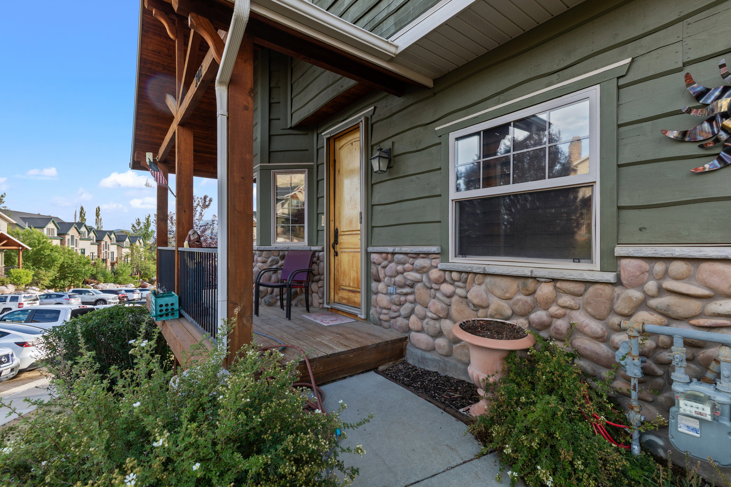 Property entrance with covered porch and stone siding