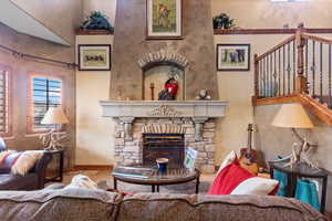 Living area with a fireplace and a towering ceiling