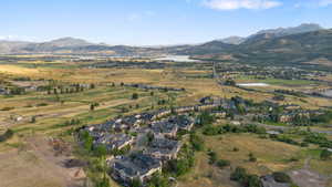 Aerial overview of property's location featuring a water and mountain view and nearby suburban area