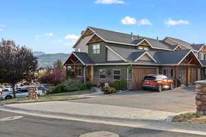 Craftsman-style home featuring stone siding, concrete driveway, and a mountain view