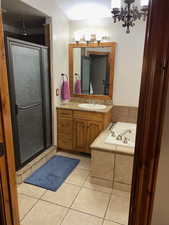 Bathroom with a stall shower, tile patterned floors, vanity, a garden tub, and a textured ceiling