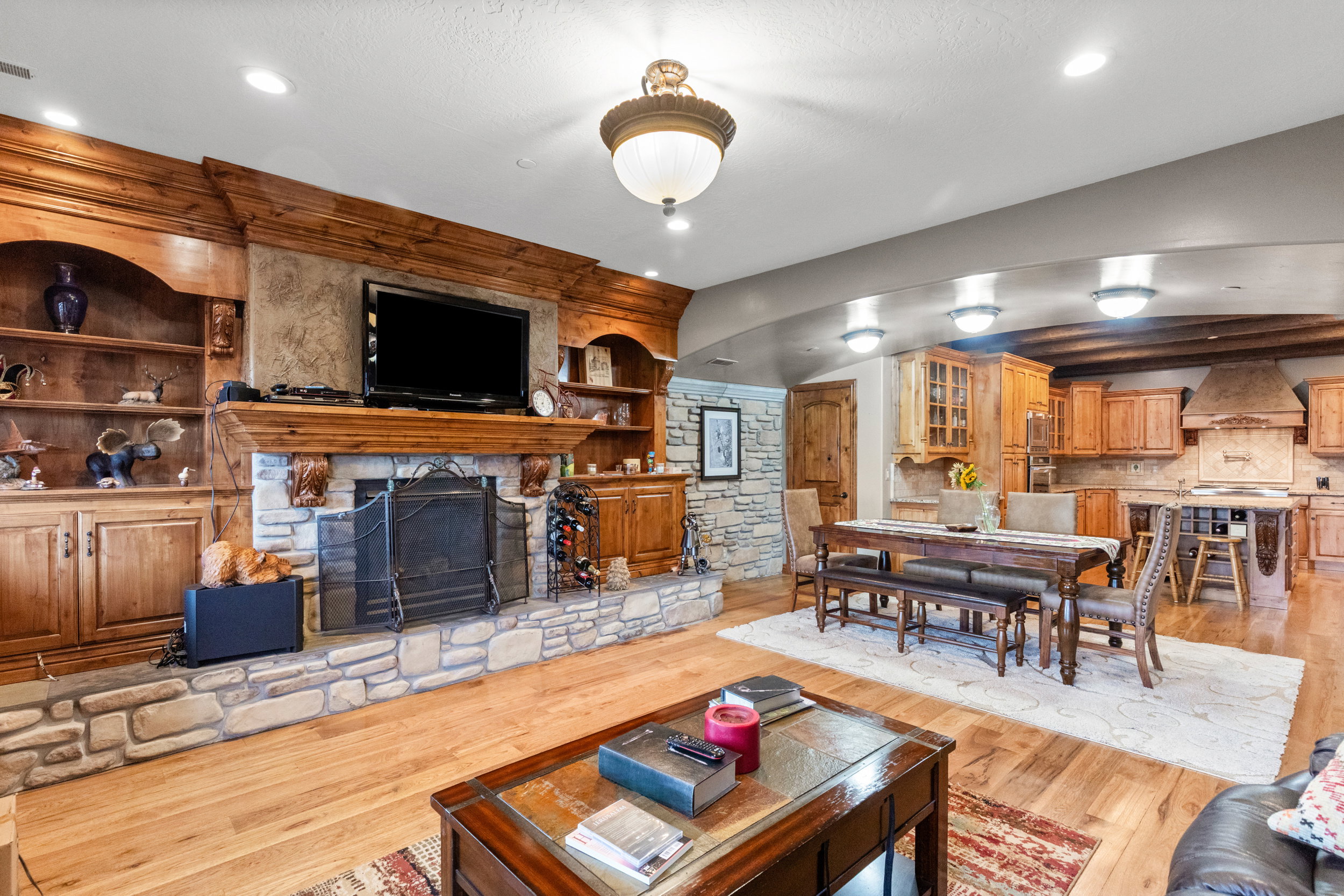 Living room with a fireplace, light wood-style floors, recessed lighting, and built in shelves
