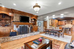 Living room with a fireplace, light wood-style floors, recessed lighting, and built in shelves