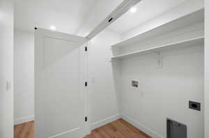Laundry room with light wood-style flooring, washer hookup, electric dryer hookup, and recessed lighting
