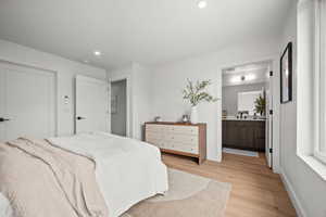 Primary Bedroom with light wood-style flooring, recessed lighting, and ensuite bath