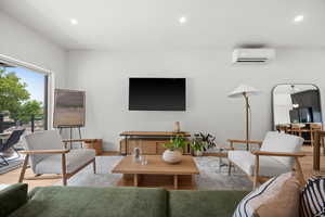 Living room featuring light wood finish LVP floors, recessed lighting,  and a wall mounted air conditioner
