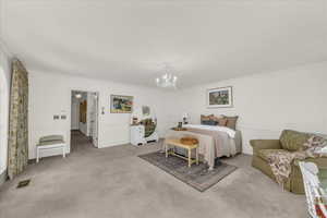 Carpeted bedroom featuring a chandelier and crown molding