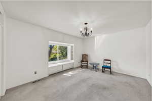 Unfurnished room with carpet flooring and a chandelier