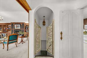 Hallway with carpet flooring and arched walkways
