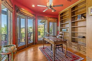 Library or Office with wall of windows, custom drapery and custom floor to ceiling book shelves.