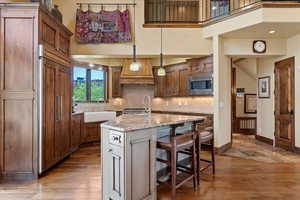 Custom kitchen with deep farm sink, Wolf Appliances, Adler Wood cabinets, tile back splash and granite counters.
