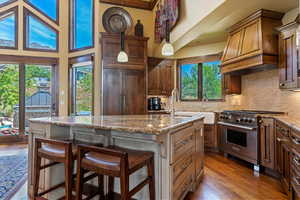 Custom kitchen with deep farm sink, Wolf Appliances, Adler Wood cabinets, tile back splash and granite counters. Large center island .