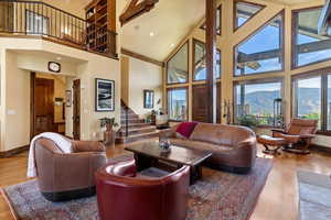 Main level Living area featuring a stone fireplace, Walnut wood floors, cathedral ceilings and recessed lighting. Mountain views from floor to ceiling windows.