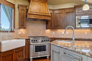 Custom kitchen with deep farm sink, Wolf Appliances, Adler Wood cabinets, tile back splash and granite counters.
