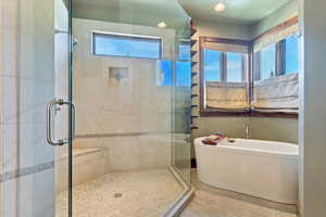 Glass shower and large soaking tub in main level primary bath.